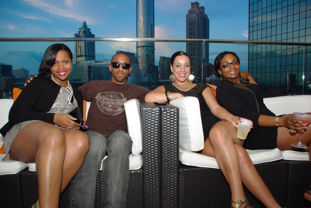 African-American group posing in front of the Atlanta skyline