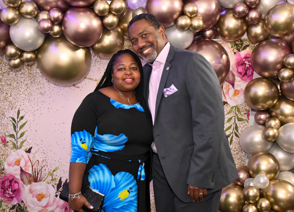 African-American couple posing in front of a balloon background