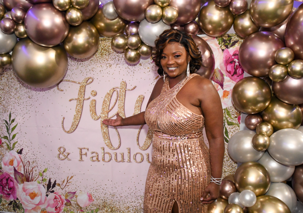 African-American woman posing in front of a balloon background