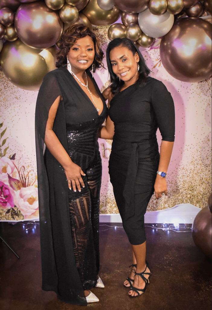 African-American women posing in front of a balloon background