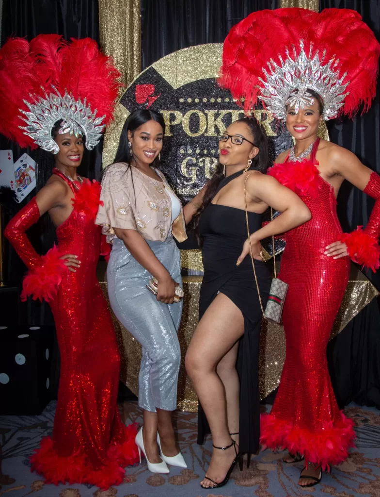 African-American women posing in front of black and gold poker background