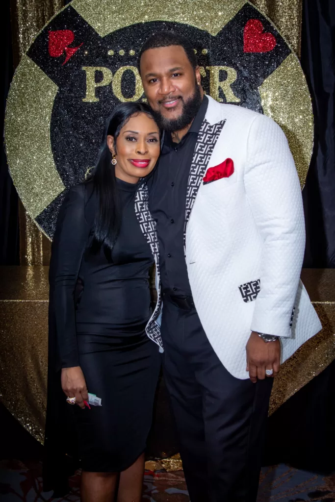 African-American couple posing in front of black and gold poker background